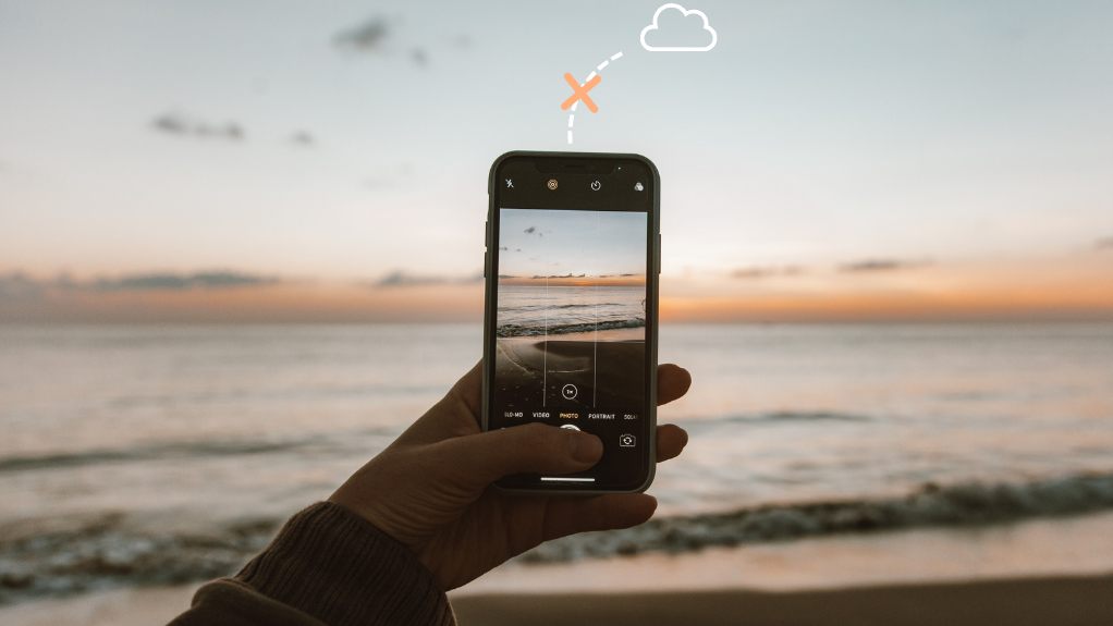 Phone taking a photo at the beach, with the path to a cloud icon crossed out