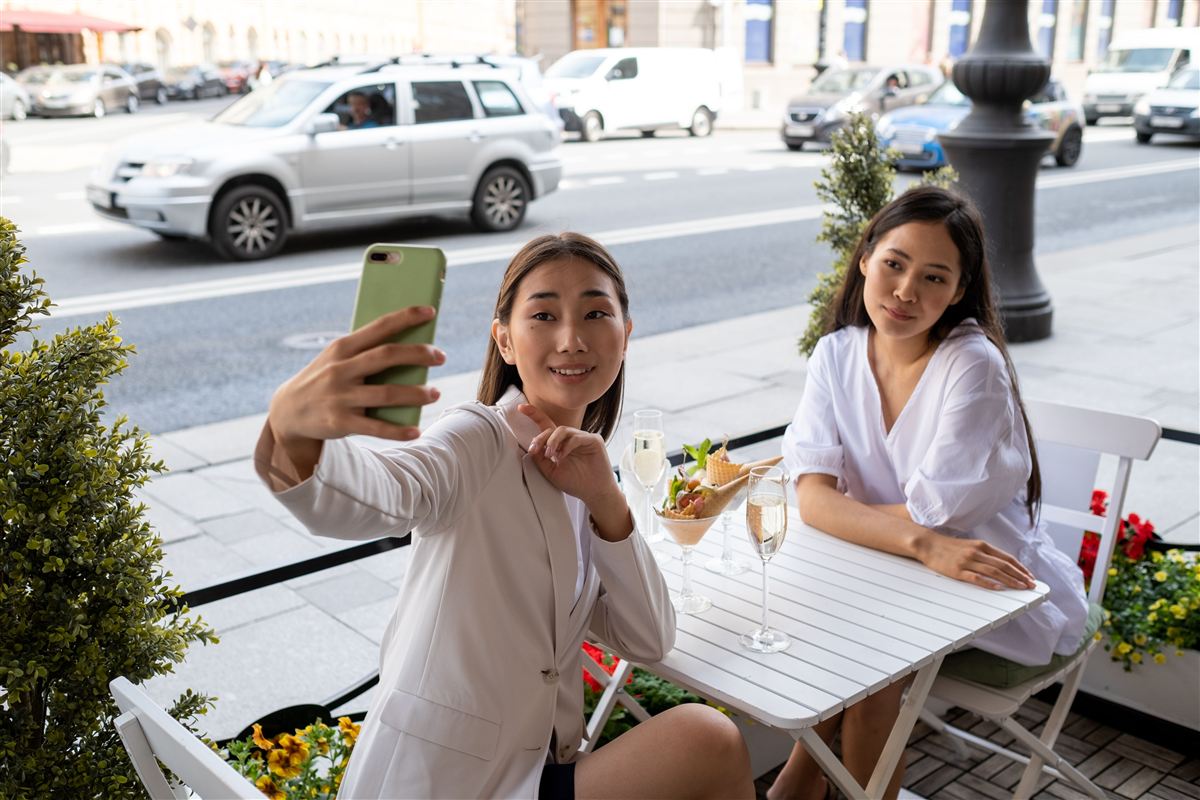 Two friends taking a selfie at a cafe