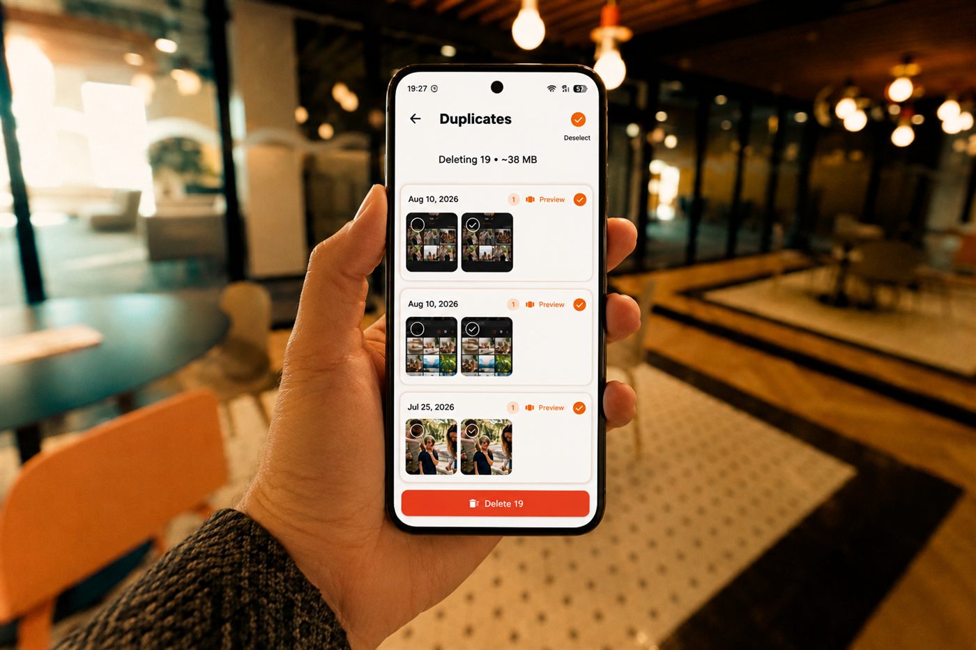 Hand holding a phone showing duplicate photos found by Filtored