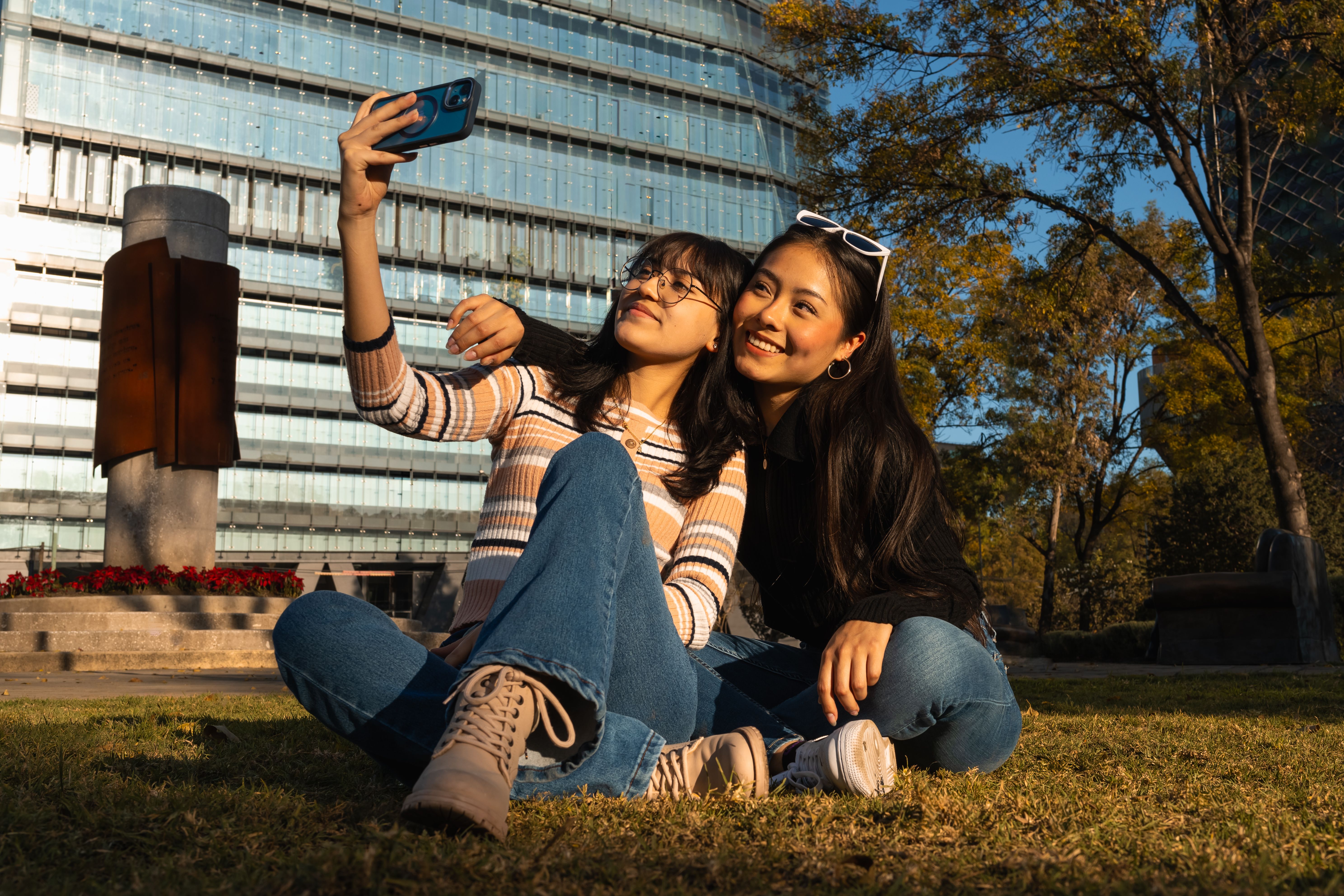 Friends taking a selfie together on grass